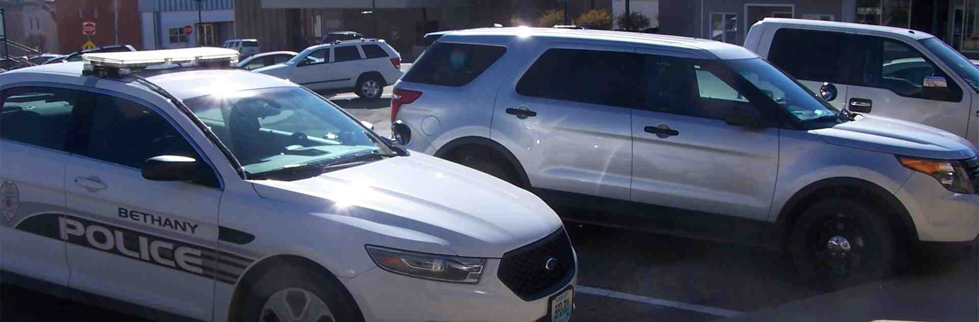 A Bethany police department vehicle parked next to other vehicles in a parking lot.