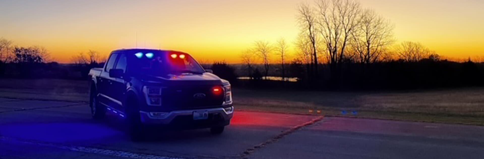 Sheriff truck with blue and red lights flashing at night.